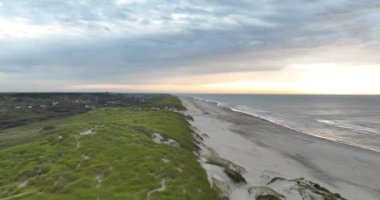 Texel, Hollanda sahillerinde yürüyen insanlar var. Deniz ve kum tepeleri genel bakış. Boş zaman ve eğlence..
