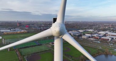 Hollanda 'nın Utrecht bölgesinde yavaş dönen rüzgar türbinlerinin havası. Sürdürülebilir enerji, yakın görüş. Rüzgâr enerjisi.