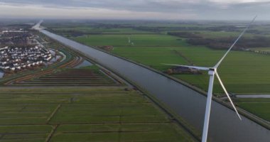 Hollanda 'nın Utrecht bölgesinde yavaş dönen rüzgar türbinlerinin havası. Sürdürülebilir enerji, yakın görüş. Rüzgâr enerjisi.