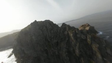 Azores, Sao Miguel, Portekiz 'deki engebeli kayalıklara dalış yapan Cliff. FPV hava görüntüsü.