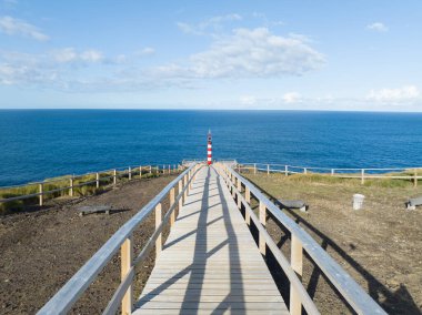 Small lighthouse on rugged cliff line of the Azores, Sao Miguel, shipping beacon, vulcanic rocks, an aerial drone video clipart