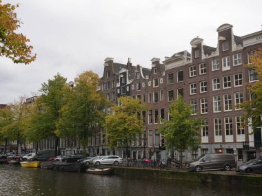 Amsterdam, Kuzey Hollanda, Hollanda, 2 Ekim 2024: Amsterdam şehir merkezindeki kanal evleri, ikonik tarihi Hollanda mimarisi, sokak manzarası. Geleneksel evler.