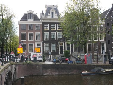 Amsterdam, Kuzey Hollanda, Hollanda, 2 Ekim 2024: Amsterdam şehir merkezindeki kanal evleri, ikonik tarihi Hollanda mimarisi, sokak manzarası. Geleneksel evler.