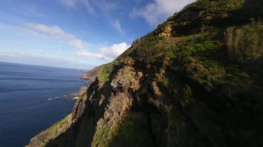 FPV volkanik kayalıklar, Atlantik okyanusu, dalgalar, güzel güneşli hava boyunca uçuyor..