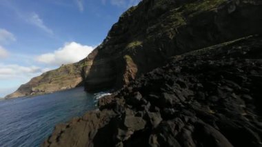FPV volkanik kayalıklar, Atlantik okyanusu, dalgalar, güzel güneşli hava boyunca uçuyor..