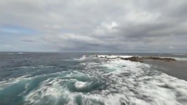 Portekiz, Azores 'in kıyı şeridindeki çarpan dalgaların üzerinden uçuyor. Atlantik Okyanusu ve volkanik kayalar, kış uykusuna yatma noktası. Hava fpv uçuşu
