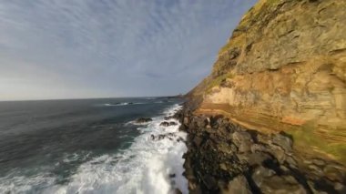 FPV İHA uçuşu Azores 'in kayalıkları boyunca, Sao Miguel. Çarpıcı dalgalar, volkanik kayalar ve kayalar, bir FPV insansız hava aracı..