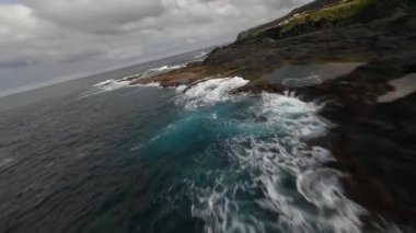 FPV volkanik kayalıklar, Atlantik okyanusu, dalgalar, güzel güneşli hava boyunca uçuyor..