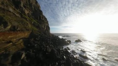 FPV İHA uçuşu Azores 'in kayalıkları boyunca, Sao Miguel. Çarpıcı dalgalar, volkanik kayalar ve kayalar, bir FPV insansız hava aracı..