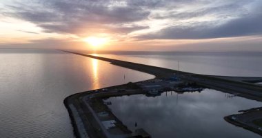 Hollandalı ikonik Afsluitdijk, Breezanddijk, Hollanda 'nın ortasındaki küçük cennet. Gün batımında açık deniz. Hava görünümleri.