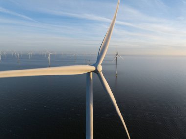 Suyun üzerindeki Afsluitdijk 'te rüzgar türbinleri rüzgarın kinetik enerjisini sürdürülebilir elektrik enerjisine rüzgar çiftliklerine ve Hollanda' da yenilenebilir enerjiye dönüştürür. Hava aracı görünümü.