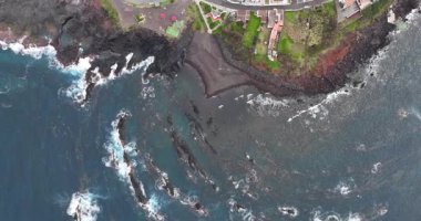 Azores kıyılarında volkanik kayalar ve çarpan dalgalar var. Yukarıdan aşağıya hava aracı görünümü.