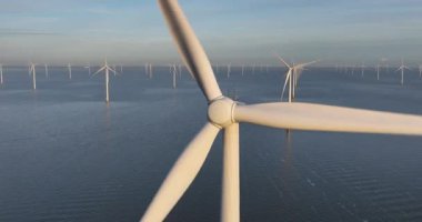 Hava aracı görüntüsü, açık deniz rüzgar parkındaki büyük rüzgar türbinlerinin görüntülerini kapatıyor..
