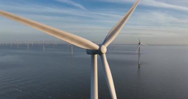 Hava aracı görüntüsü, açık deniz rüzgar parkındaki büyük rüzgar türbinlerinin görüntülerini kapatıyor..