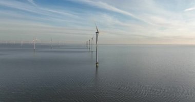 Sahil açıklarında sürdürülebilir rüzgar türbinleri gün batımında. Hollanda, Afsluitdijk. Hava görünümü.