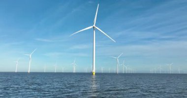 Açık denizde rüzgar türbini, suyun üzerinde alçaktan uçuyor. Hava aracı görünümü.