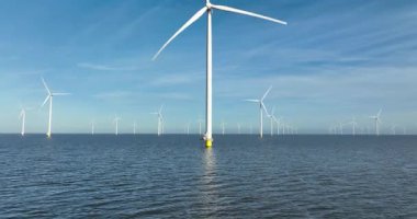 Hollanda, Avrupa 'daki Ijsselmeer' de rüzgar türbinleriyle kıyı ötesi rüzgar çiftliğinin insansız hava aracı görüntüsü. Rüzgâr türbinleri, mavi, sakin su üzerindeki rüzgar değirmenleri.