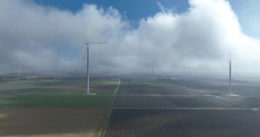 Rüzgar türbinleri alçak asılı bulutlarla, hava aracı görüntüleriyle çevrili. Hollanda 'da..