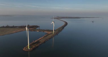 Hollanda 'da günbatımında rüzgar türbinlerinde hava aracı görüntüsü.