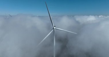 Alçak asılı bulutlarda rüzgar türbinleri, yeşil rüzgar enerjisi. sürdürülebilir enerji ve yenilenebilir enerji. Hava görünümü.
