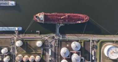 Petrol gemisinin yükleme ve boşaltma terminalinin yukarıdan aşağı görüntüsü. Benzin için depo ambarları, sıvılar. Tanker limanda. Küresel lojistik nakliyesi. Hava görünümü.