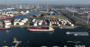 Amsterdam Limanı, Hemweg merkezi, elektrik santrali, petrol depolama siloları, gemiler, petrol tankerleri, petrokimyasal limanlar. Su üzerinde küresel ulaşım. Hollanda 'da. Dünya ticareti. Hava görünümü.
