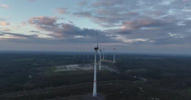 Almanya 'da yenilenebilir enerji, günbatımında rüzgar türbinleri. Hava aracı görünümü.