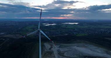 Almanya 'da yenilenebilir enerji, günbatımında rüzgar türbinleri. Hava aracı görünümü.
