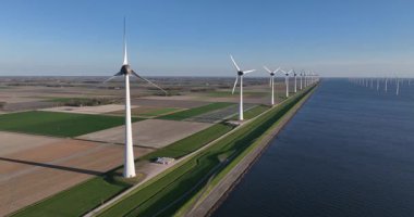 Güneş lekelenebilir, yenilenebilir enerji, Hollanda 'da enerji geçişi. Rüzgar türbinleri, lale tarlaları arasındaki su hattı boyunca esiyor. Hava görünümü.