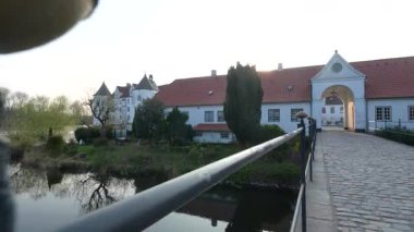 Glucksburg Şatosu, tarihi anıt kale ve kale gölü, günbatımı manzaralı, Kuzey Almanya Flensburg yakınlarında. Bakış açısı.