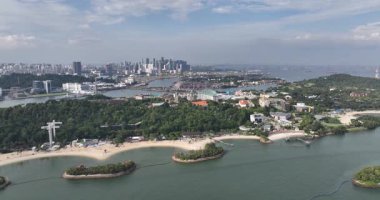 SIngapore 'un ufuk çizgisi, Güney Doğu Asya, Sentosa adası, gemiler, okyanus. Hava aracı videosu.