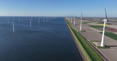 Temiz enerji, suda rüzgar enerjisi, rüzgar türbinleri, Hollanda, hava aracı videosu. Enerji geçişi. İklim değişikliği çözümü. Rüzgardan gelen enerji. Hava aracı görünümü.