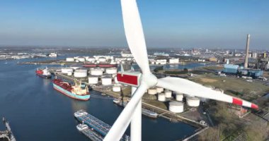 Amsterdam limanında yenilenebilir enerji, rüzgar türbini, yakın görüş. Depo siloları, su yolu, ticaret lojistik ve ulaşım. Hava görünümü.