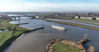 İç sularda, Lek Nehri 'ndeki sanayi gemisinde, Hollanda' da. Hava aracı videosu. Endüstriyel malzeme nakli. Hava görünümü.