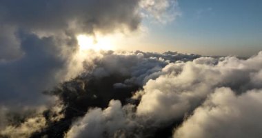 Bulutlardaki hava görüntüleri, beyaz bulutlar güneş, gökyüzü bulutların arasında uçuyor. Drone görünümü.