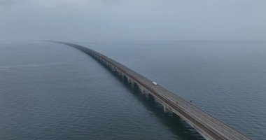 Denizde sonsuz bir köprü, sonsuz bir köprü, ulaşım altyapısı, sisli, sisli, gizemli. Hava aracı videosu.