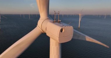 Rüzgar türbinleri günbatımında okyanusun ortasında, rüzgarın yenilenebilir enerji üretme gücü. Hollanda 'da denizdeki yel değirmeni türbinlerini kapatın. Hava görünümü.