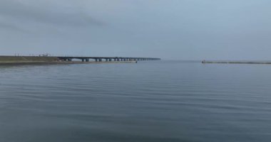 Denizde sonsuz bir köprü, sonsuz bir köprü, ulaşım altyapısı, sisli, sisli, gizemli. Hava aracı videosu.