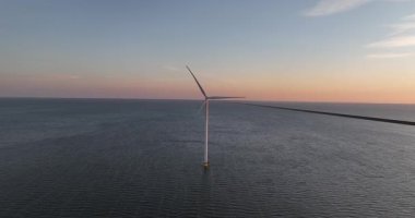Rüzgar türbinleri günbatımında okyanusun ortasında, rüzgarın yenilenebilir enerji üretme gücü. Hollanda 'da denizdeki yel değirmeni türbinlerini kapatın. Hava görünümü.
