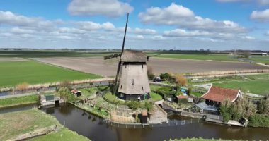 Geleneksel rüzgar değirmeni, Hollanda kırsalında. Hollanda tarihi ikonu, tarım arazisi, Hollanda kültürü, Hollanda mühendisliği. Hava aracı görünümü.