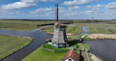 Geleneksel rüzgar değirmeni, Hollanda kırsalında. Hollanda tarihi ikonu, tarım arazisi, Hollanda kültürü, Hollanda mühendisliği. Hava aracı görünümü.