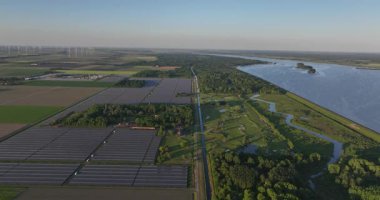 Büyük güneş panelleri alanı, güneşten gelen enerji, enerji geçişi, güneş enerjisi. Hava görüntüsü. Biddinghuizen, Flevoland, Hollanda. Hava aracı videosu.