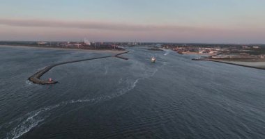 Kuzey Denizi 'ne doğru ilerleyen bir iskele. Küçük deniz feneri feneri, Ijmuiden, Hollanda. Günbatımı hava görüntüsü.
