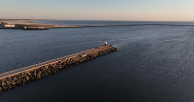 Kuzey Denizi 'ne doğru ilerleyen bir iskele. Küçük deniz feneri feneri, Ijmuiden, Hollanda. Günbatımı hava görüntüsü.