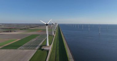 Yenilenebilir enerji, yenilenebilir kaynak, rüzgardan gelen enerji, doğadan gelen enerji. Temiz elektrik üretimi. Hava aracı görüntüsü. Kır manzarası, su hattı.