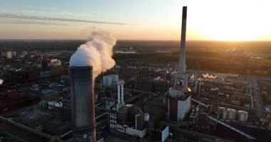 Almanya 'nın ruhr bölgesindeki sanayi bölgesinde gün batımında baca dumanı yığıyor. Hava aracı görüntüsü. Üretim ve üretim, endüstriyel, imalat.