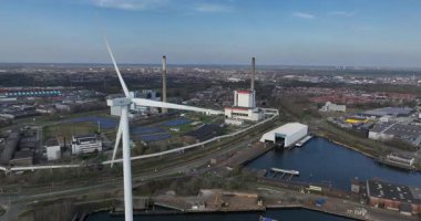 Velsen Noord, Kuzey Hollanda, Hollanda, 3 Nisan 2025: Velsen Noord 'daki elektrik santrali ve rüzgar türbinleri, enerji endüstrisi. Hava videosu.