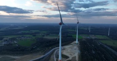 Rüzgar türbinlerinin temiz yenilenebilir enerjisi güzel bir gökyüzü, gün batımı, hava videosu altında.