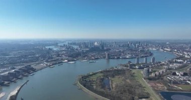 Rotterdam ufuk çizgisi üzerindeki şehir manzarası, SOuth Holland, Hollanda, Nieuwe Maas nehri, su üzerindeki güneş paneli. Hava aracı videosu