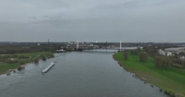 Almanya, Duisburg 'daki Ren Nehri üzerinde trafik altyapısı, su yolu ve karayolu geçişine odaklanan bir köprünün insansız hava aracı videosu..